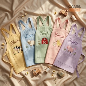 Könnte beinhalten: Fünf Kinderschürzen in Gelb, Hellblau, Salbeigrün, Hellrosa und Lavendel. Jede Schürze hat ein überkreuztes Rückendesign, eine Vordertasche und gestickte Namen: Oliver, Liam, Noah, Emma und Sophia, kombiniert mit Bauernhof- oder Scheunenmotiven.