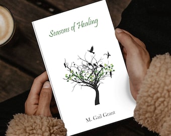 May include: A white book cover with the title "Seasons of Healing" in green cursive text. A black silhouette of a tree with green leaves and birds is in the center. The author's name, "M. Gail Grant", is printed in black at the bottom.