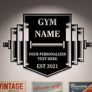 Op de afbeelding: Zwart en wit gymbord met de tekst "GYM NAME", "YOUR PERSONALIZED TEXT HERE" en "EST 2021". Omringd door vintage raceauto posters en modelauto's op planken.