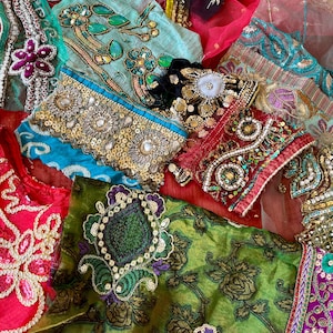 Peut inclure: Une collection de chutes de tissus assorties ornées de broderies complexes, de paillettes dorées métalliques et de perles colorées. Les textiles présentent diverses textures et motifs dans des tons de vert, bleu, rouge, violet et noir.