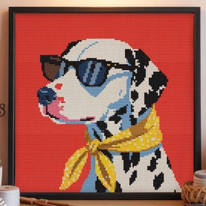 Puede incluir: Arte de punto de cruz de un perro dálmata con gafas de sol y un pañuelo amarillo, sobre un fondo rojo. El perro tiene manchas negras y está enmarcado en un cuadrado negro.