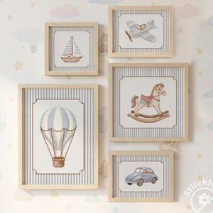 Könnte beinhalten: Fünf gerahmte Kreuzstich-Kunstwerke mit einem Kinderzimmer-Thema. Die Bilder zeigen ein Segelboot, ein Flugzeug, einen Heißluftballon, ein Schaukelpferd und ein Oldtimer. Jedes Kunstwerk ist in einem hellen Holzrahmen gerahmt.
