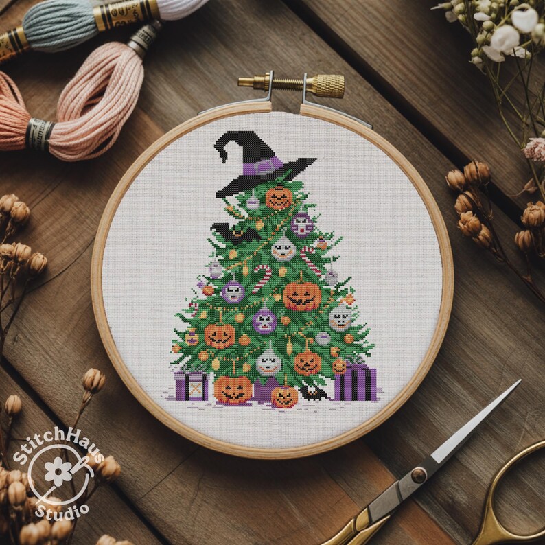 May include: A cross-stitch embroidery of a Halloween-themed Christmas tree, adorned with jack-o'-lanterns, ornaments, and a witch's hat. The design is set in a wooden embroidery hoop, with spools of thread and scissors in the background.