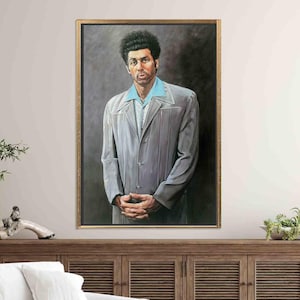 May include: A framed portrait of a man in a gray suit with a light blue shirt. The painting has a gold frame and is displayed on a wooden cabinet. The man has dark curly hair and is looking directly at the viewer.