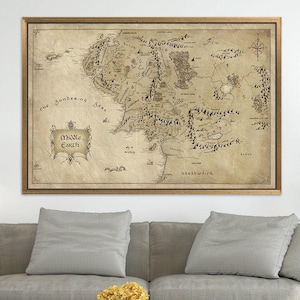 Peut inclure: Une carte encadrée de la Terre du Milieu, avec des illustrations détaillées de montagnes, de rivières et d'établissements. La carte est imprimée sur du papier vieilli avec une rose des vents et des bordures décoratives. Le texte "Middle Earth" est affiché.