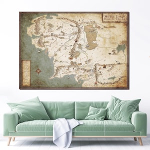 Könnte beinhalten: Eine gerahmte Karte von Mittelerde während des Dritten Zeitalters. Die Karte ist in Braun-, Beige- und Grüntönen gehalten und zeigt detaillierte Illustrationen des Landes. Die Karte enthält eine Legende und eine Windrose. Der Rahmen ist dunkelbraun.