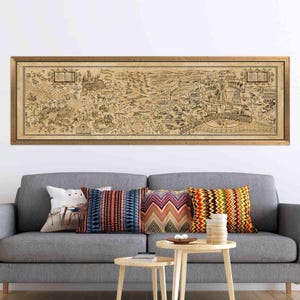 May include: A framed, sepia-toned map illustration with intricate details, depicting a fantastical landscape. The map is in a wooden frame and hangs above a gray sofa with colorful throw pillows. The map's dimensions are approximately 60 inches wide.