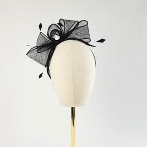 May include: Black mesh hair comb with a large bow. The comb is on a white mannequin head.