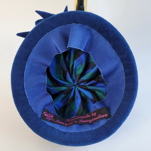 May include: A blue velvet hat with a blue ribbon and a plaid lining. The hat has a label that reads "Handmade by Imogen's Imagination".