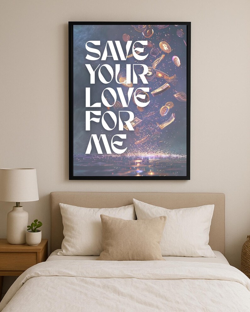 May include: A framed art print with the text "SAVE YOUR LOVE FOR ME" in white, stylized lettering. The artwork features falling coins and currency against a dark background. The print is displayed above a bed with white bedding and pillows.
