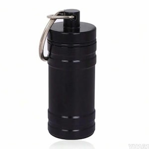May include: A cylindrical black metal container with a screw-top lid and a silver-toned metal split ring attached to the top. The exterior features horizontal grooves near the top and bottom, and the text YH161 is visible in the bottom right corner.