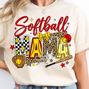 May include: Cream-colored t-shirt with the words "Softball Mama" in red script. The word "MAMA" is designed with a checkerboard pattern, leopard print, and yellow stripes. A softball glove, ball, and bat are also featured.