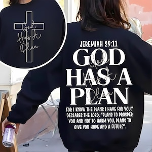 May include: Black sweatshirt with the text "God Has A Plan" and a cross graphic on the front. The back of the sweatshirt features the text "Jeremiah 29:11" and the words "God Has A Plan" in large white letters, along with a Bible verse.