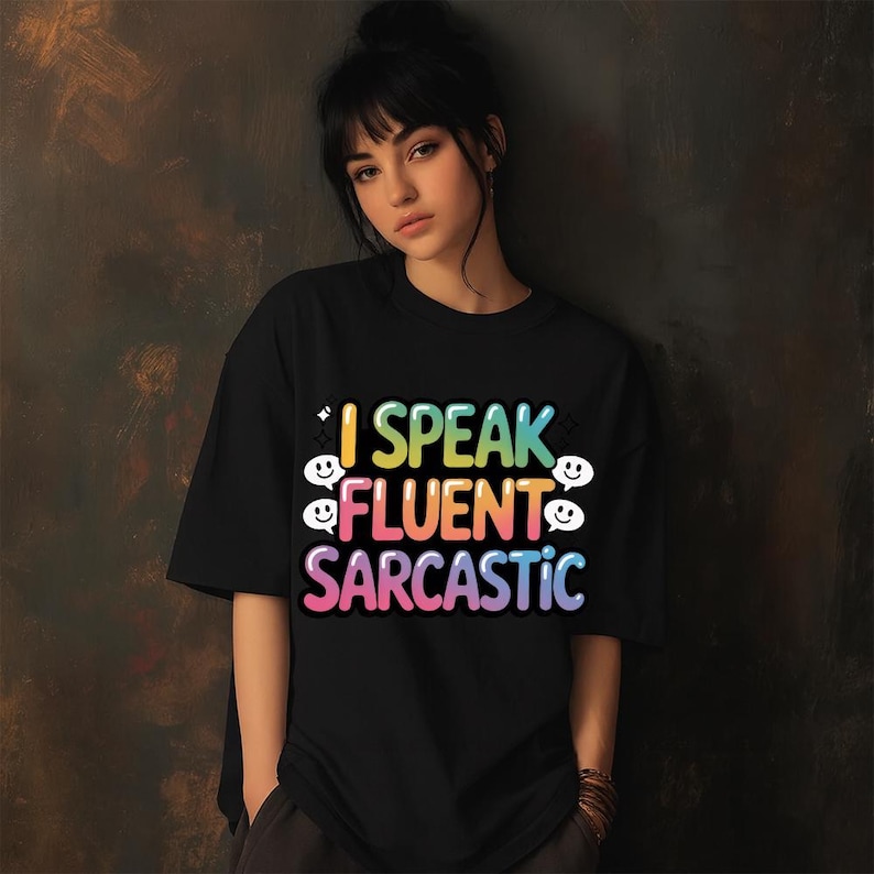 May include: Black t-shirt with the text "I Speak Fluent Sarcastic" in a colorful, rainbow-gradient font. The design includes smiley face graphics. The shirt is a casual, oversized style.