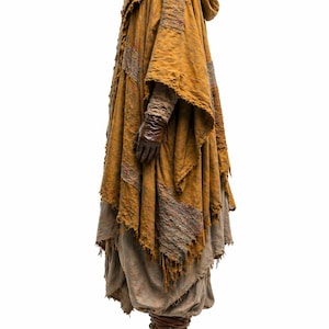 K&ouml;nnte beinhalten: Ein senffarbener Kapuzenmantel mit zerfransten Kanten und Flicken aus rotem und grauem Stoff. Der Umhang wird &uuml;ber einem mehrschichtigen Outfit getragen, darunter ein langer Rock und braune Stiefel. Braune Lederhandschuhe vervollst&auml;ndigen den Look.