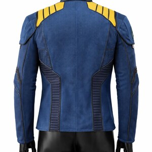 Puede incluir: Chaqueta azul con detalles amarillos en los hombros y ribetes azul oscuro. La chaqueta tiene un aspecto texturizado y presenta paneles acolchados en los laterales y la espalda. La chaqueta se muestra en un maniqu&iacute; negro.