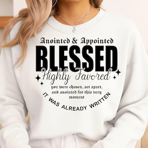 Puede incluir: Sudadera blanca con el texto negro "Anointed & Appointed BLESSED Highly Favored". Texto adicional: "you were chosen, set apart, and anointed for this very moment. IT WAS ALREADY WRITTEN."