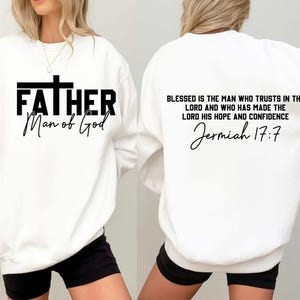 Op de afbeelding: Witte sweatshirt met de tekst "FATHER Man of God" in zwart op de voorkant. De achterkant van de sweatshirt heeft de tekst "BLESSED IS THE MAN WHO TRUSTS IN THE LORD AND WHO HAS MADE THE LORD HIS HOPE AND CONFIDENCE Jermiah 17:7".