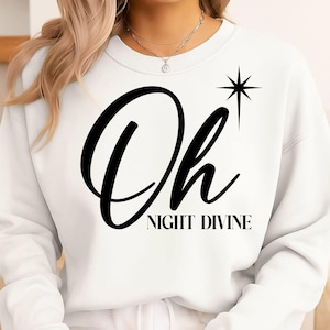 Può includere: Felpa bianca con le parole "Oh NIGHT DIVINE" in corsivo nero. Un disegno a stella nera è a destra della parola "Oh". La felpa è uno stile casual.