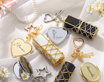 May include: An assortment of personalized keychains and compact mirrors in gold, silver, and black. The keychains feature heart, star, and rectangular shapes, some with names like "Elaine" and "Sophia". The compact mirrors have a decorative net-like design.