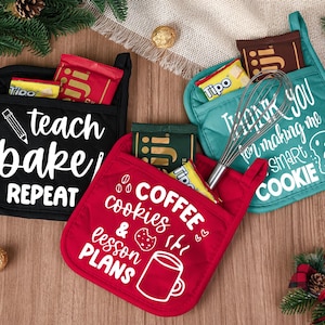 Könnte beinhalten: Drei bunte Topflappen mit Taschen, jeweils gefüllt mit Snacks. Ein schwarzer Topflappen mit der Aufschrift "teach bake repeat". Ein türkisfarbener Topflappen mit der Aufschrift "Thank you for making me a smart cookie". Ein roter Topflappen mit der Aufschrift "coffee cookies & lesson plans".