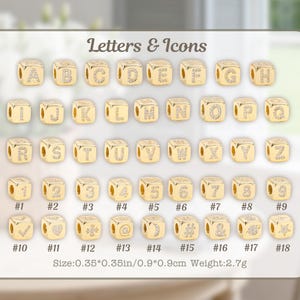 May include: Gold-colored cube beads with letters, numbers, and icons. Each cube has a letter or symbol with a clear gem. The image includes the text "Letters & Icons" and size details: 0.35*0.35 inches.