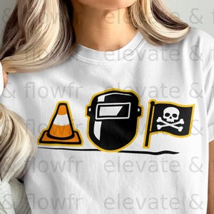 White t-shirt with graphics of a welding mask, traffic cone, and pirate flag.