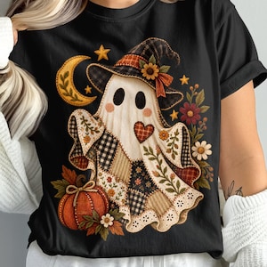 以下が含まれることがあります： 魔女の帽子をかぶったゴーストのグラフィックが描かれた黒いTシャツ。パッチワーク柄、ハート、三日月、カボチャ、様々な花で装飾されています。ゴーストは白い体に黒い目とピンクの頬をしています。