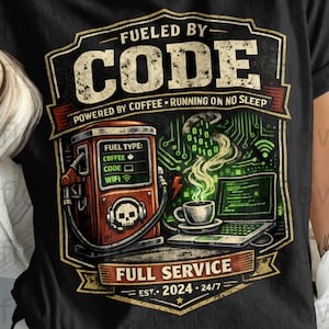 Può includere: T-shirt nero con un design grafico raffigurante una pompa di benzina retrò con "FUEL TYPE: COFFEE, CODE, WIFI" e un laptop. Il testo recita "FUELED BY CODE" e "FULL SERVICE EST. 2024 24/7".