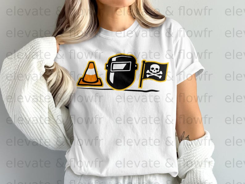 White t-shirt with graphics of a welding mask, traffic cone, and pirate flag.