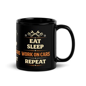 以下が含まれることがあります： 白とオレンジ色の「EAT SLEEP WORK ON CARS REPEAT」の文字が入った黒いセラミックマグ。マグカップには、レンチとピストンの交差グラフィックが描かれています。車好きの方へのプレゼントに最適です。