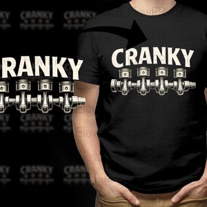 Puede incluir: Camiseta negra con la palabra "CRANKY" en blanco, sobre una ilustración detallada de un cigüeñal y pistones de motor. El diseño se repite en el lado izquierdo.