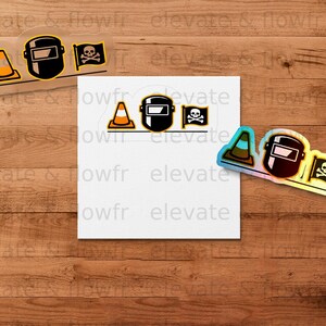Construction helmet, skull and crossbones stickers on a wooden background.