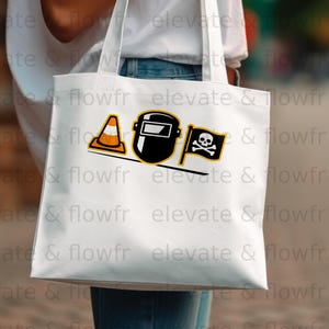 White tote bag with black and orange welding mask and skull crossbones graphic.