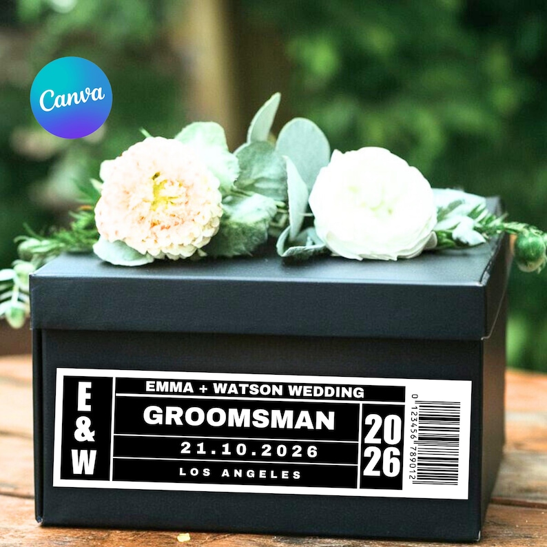 Pu&ograve; includere: Una scatola regalo nera con un'etichetta bianca che recita "EMMA + WATSON WEDDING GROOMSMAN 21.10.2026 LOS ANGELES". La scatola &egrave; decorata con fiori bianchi e color pesca e verde. La scatola ha un codice a barre.