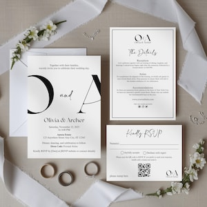 以下が含まれることがあります： ミニマルなデザインのエレガントなウェディング招待状セット。招待状、詳細カード、RSVPカードが含まれており、すべて白地に黒文字です。指輪、花、リボンがプレゼンテーションを完成させています。