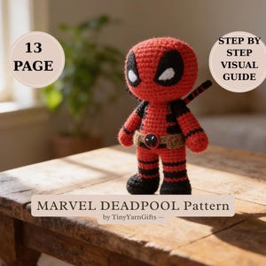 May include: A handmade, red and black crocheted Deadpool figure with a utility belt. The figure has white eyes and a black mask outline. The image includes text that reads "MARVEL DEADPOOL Pattern" and "13 PAGE".