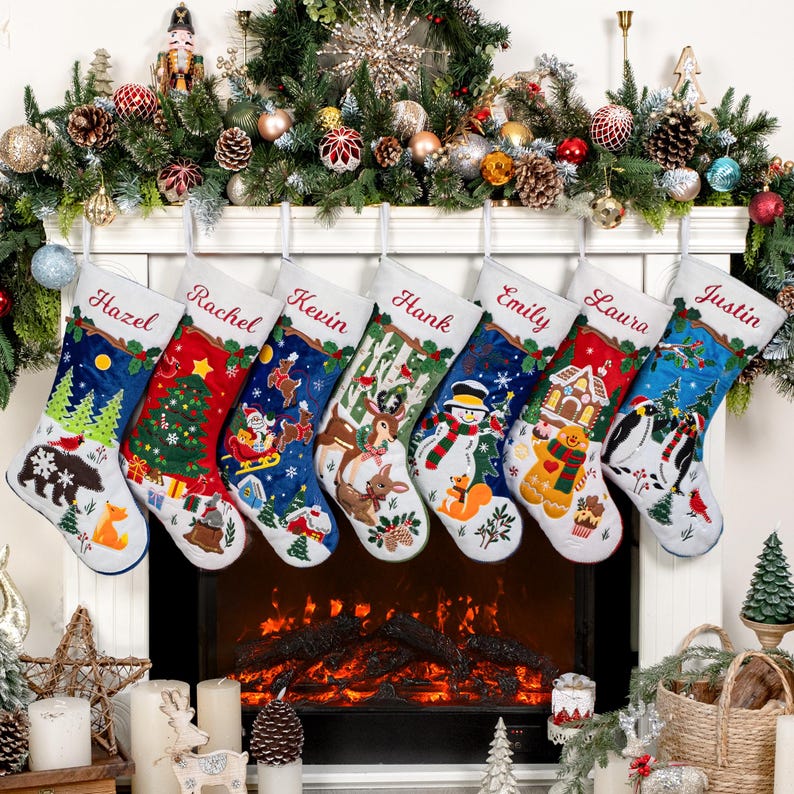 May include: Seven personalized Christmas stockings hanging in a row, each featuring unique embroidered holiday scenes including a bear, Santa, reindeer, snowman, gingerbread man, and penguins, with names Hazel, Rachel, Kevin, Hank, Emily, Laura, and Justin.