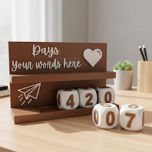 May include: A brown wooden desk calendar stand featuring a shelf and the white text "Days your words here" next to a white heart icon and a paper airplane graphic. The stand includes white cubes with brown numbers for tracking dates.