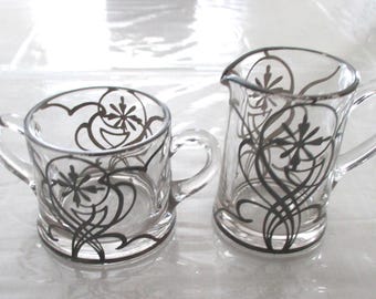 Juego de azucarero y cremera de cristal con revestimiento de plata, estilo Art Nouveau.