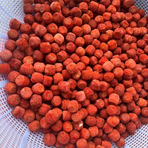 Puede incluir: Una gran colecci&oacute;n de peque&ntilde;os alimentos redondos de color rojo vibrante con una superficie texturizada y porosa. Estas piezas esf&eacute;ricas est&aacute;n amontonadas dentro de un colador de pl&aacute;stico blanco con un patr&oacute;n de rejilla de ranuras.