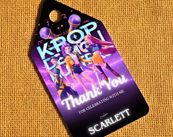 May include: A black tag with a hole at the top, featuring a K-Pop Dance theme. The tag has an illustration of three female figures and the words "Thank You" and "For Celebrating With Me". The name "Scarlett" is at the bottom.