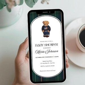 Może przedstawiać: Smartfon wyświetla zaproszenie na baby shower. Zaproszenie zawiera misia w swetrze z amerykańską flagą. Tekst zawiera "Baby Shower" oraz szczegóły wydarzenia Marii Johnson, w tym datę, godzinę i miejsce.