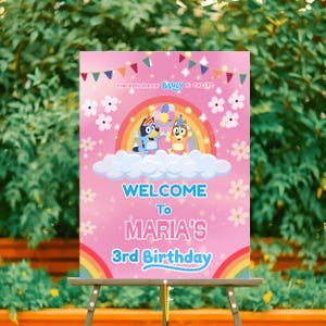 Puede incluir: Un letrero de bienvenida rosa para una fiesta de cumpleaños con el texto "Bienvenida al 3er cumpleaños de María". El letrero presenta personajes de dibujos animados, un arcoíris y detalles florales. La parte superior del letrero dice "El episodio de Bluey se llama".