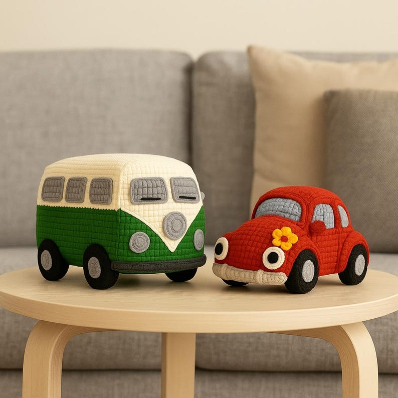 May include: Two handmade, stuffed toy vehicles: a green and cream-colored bus and a red car with a yellow flower. The bus has black wheels and gray windows. The car has black wheels and a cream-colored bumper. Both are on a light brown table.