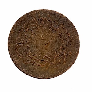 May include: A round, antique bronze coin with intricate embossed designs. The coin's surface shows signs of age and wear, with a dark brown patina. The design features ornate patterns and possibly text, suggesting historical significance.