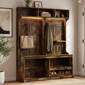 May include: A tall, dark brown wood-grain hall tree featuring an upper storage shelf, a central panel with multiple metal hooks, and a lower bench with open cubbies for shoe storage. A beige tote bag and a green jacket hang from the hooks.