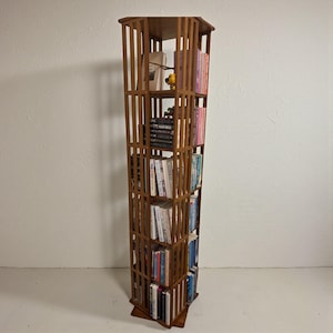 Puede incluir: Un letrero de madera hecho a mano con la palabra "Bienvenido" en una fuente juguetona. El letrero est&aacute; pintado de blanco con un acabado envejecido y presenta un dise&ntilde;o floral en tonos rosas y verdes. Mide aproximadamente 30 cm de ancho.