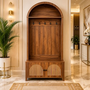 May include: A tall wooden hall tree featuring a dark walnut finish with an arched top, five black metal coat hooks, and a lower storage cabinet with two doors. The cabinet doors are accented with vertical light-colored slats in an arched pattern.