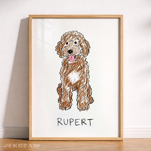 Puede incluir: Una obra de arte enmarcada con una ilustraci&oacute;n de un perro doodle marr&oacute;n. El perro est&aacute; representado sentado con la lengua fuera, dibujado con un estilo de cray&oacute;n. El nombre "RUPERT" est&aacute; escrito debajo. La obra est&aacute; en un marco de madera.